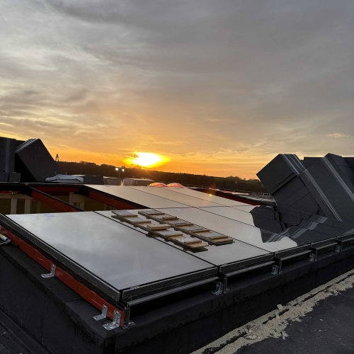 Færdigmonterede ovenlysvinduer i tagprojekt i Kolding – skinnende glas og solnedgang skaber et flot udtryk