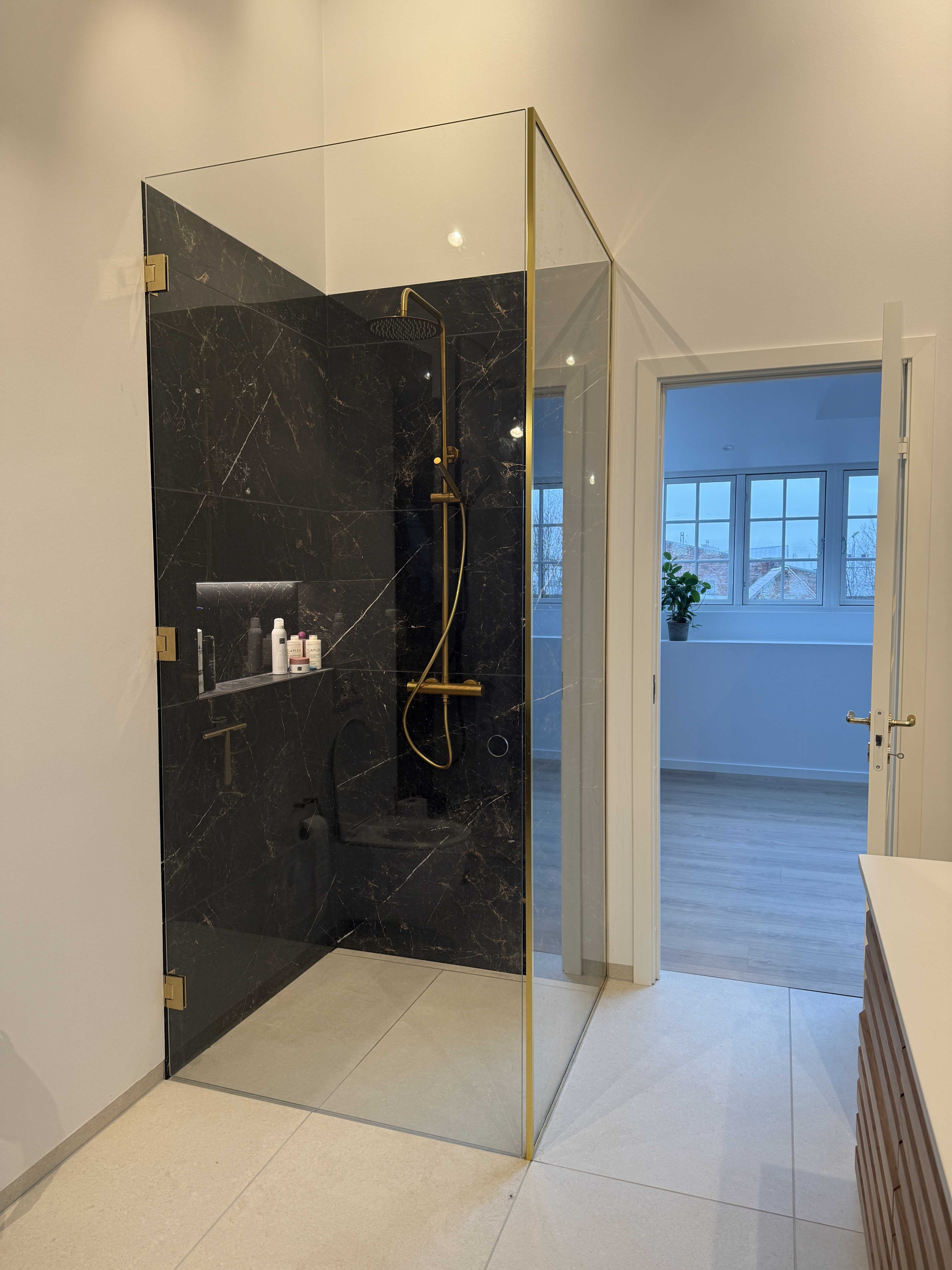 Eksklusiv brusevæg på mål i Fredericia, Kolding, Vejle og Middelfart – elegant glasløsning med messingdetaljer