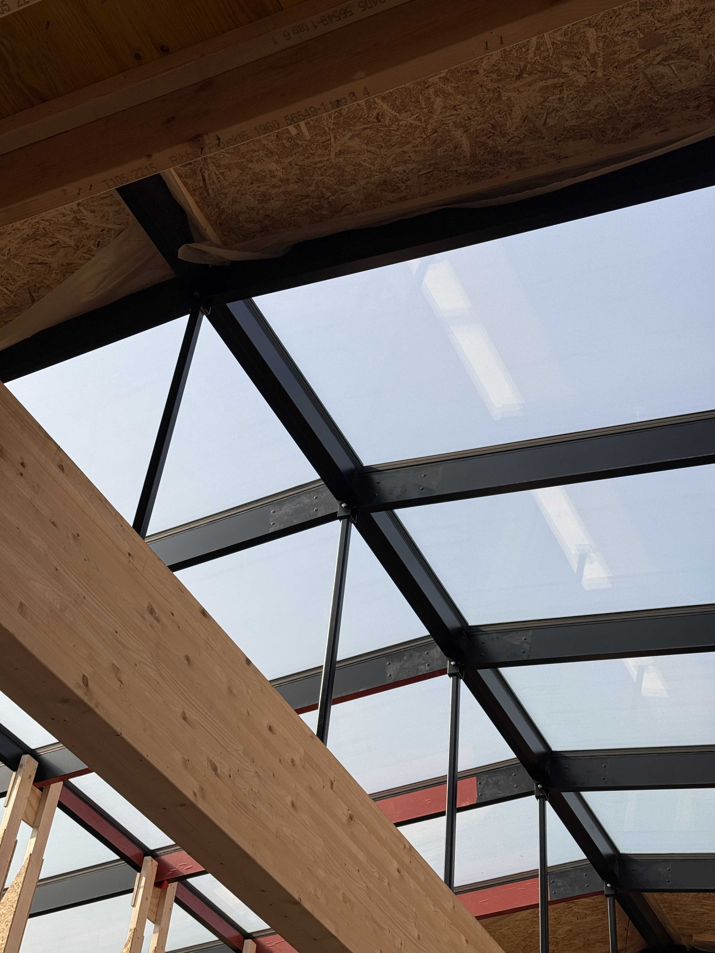 Indendørs udsigt til buede ovenlysvinduer med stålkonstruktion i Vejle – naturligt lysindfald i byggeri